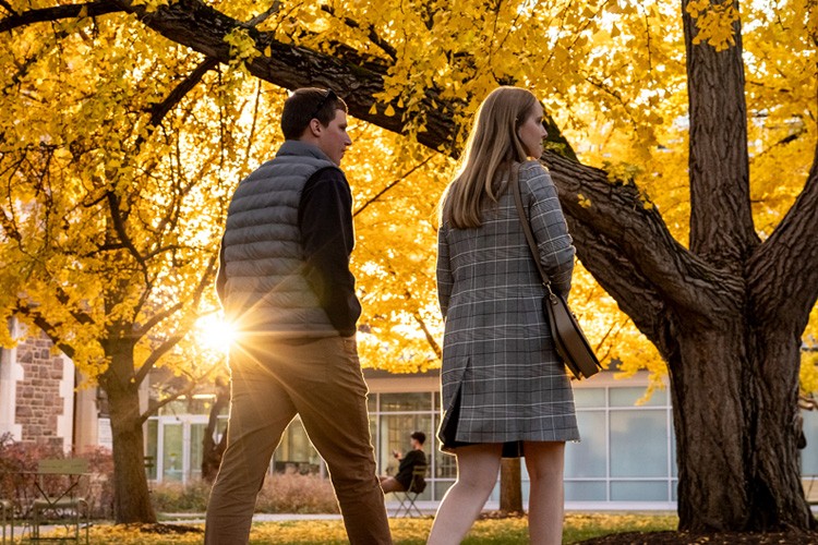 two students walking on campus in fall